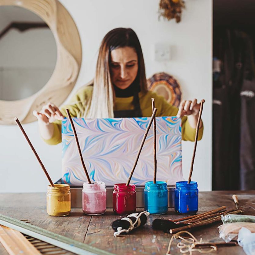 Ebru Cocak holding recently created marbled paper